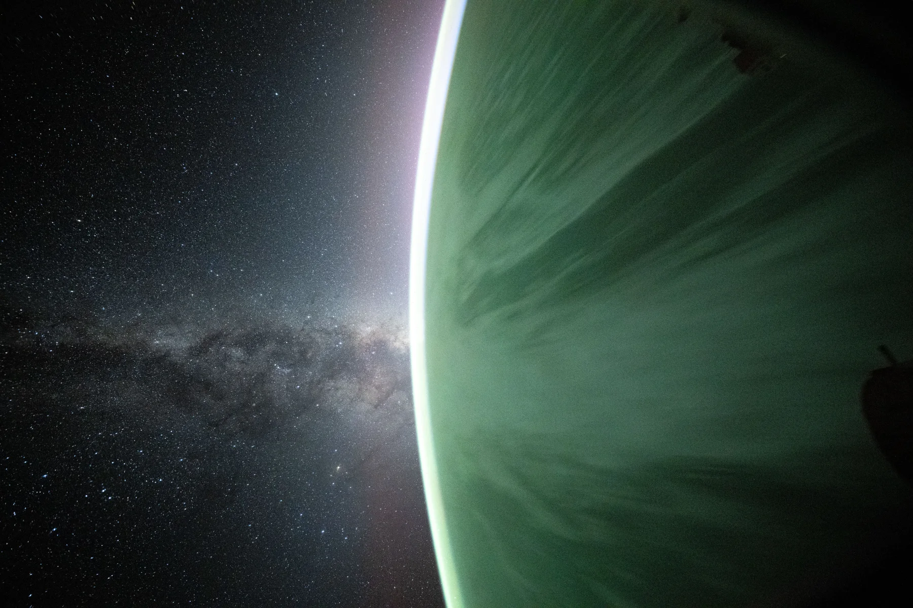 The Milky Way rising above Earth's luminous horizon, photographed from space